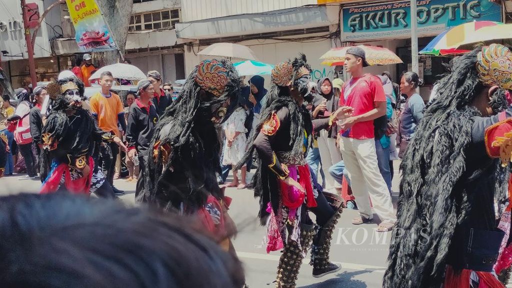Peserta kirab Jut Bio memakai kostum tarian dan menampilkan gerak tari tertentu di sepanjang rute kirab di Kota Magelang, Jawa Tengah, Minggu (1/10/2023).