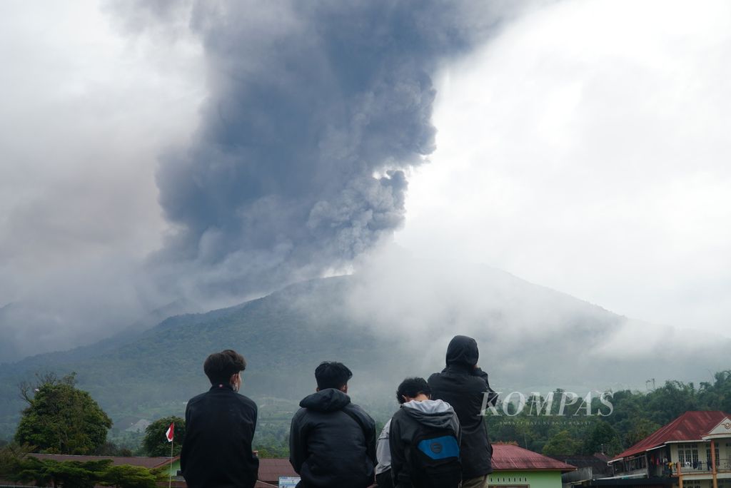 Para pemuda menyaksikan kolom abu yang keluar dari kawah Gunung Marapi di posko utama SAR, tak jauh dari Kantor Wali Nagara Batupalano, Kecamatan Sungai Pua, Agam, Sumatera Barat, Senin (4/12/2023). Kawah Marapi masih mengeluarkan asap dan abu vulkanik sejak pertama kali erupsi pada Minggu (3/12/2023) pukul 14.54.
