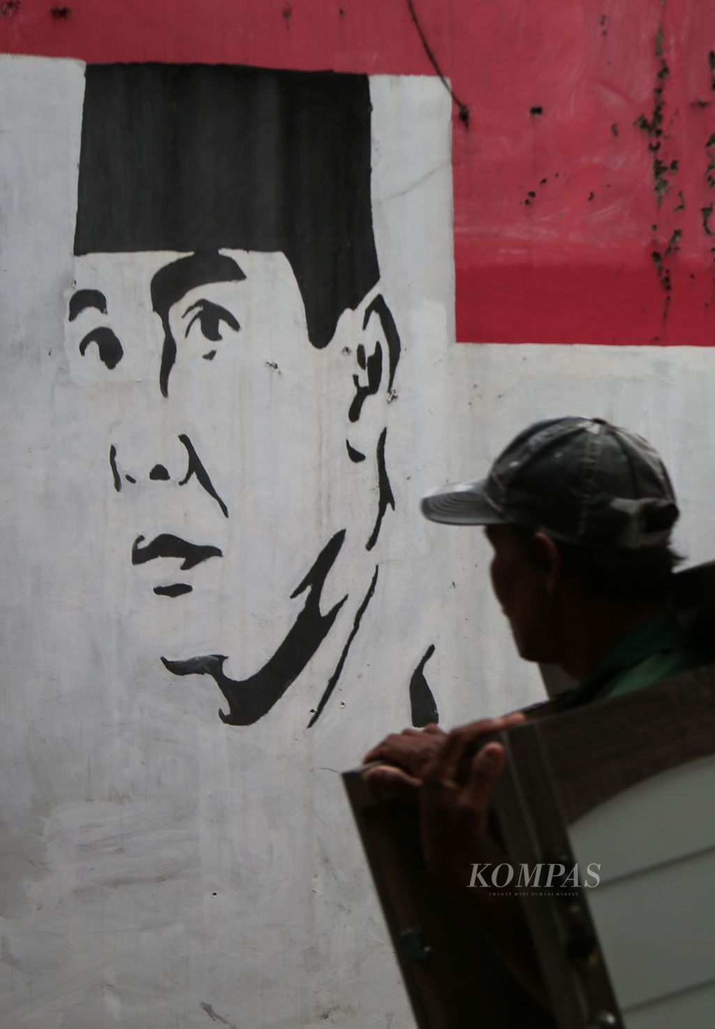 Mural Presiden pertama Republik Indonesia Ir Soekarno menghiasi tembok sebuah gang di kawasan Serua, Depok, Jawa Barat, Minggu (12/12/2021). Sosok proklamator ini masih dikenang dan dicintai rakyat. Hal itu dapat dilihat dari banyaknya mural Soekarno yang kita jumpai di berbagai media dan tempat.  