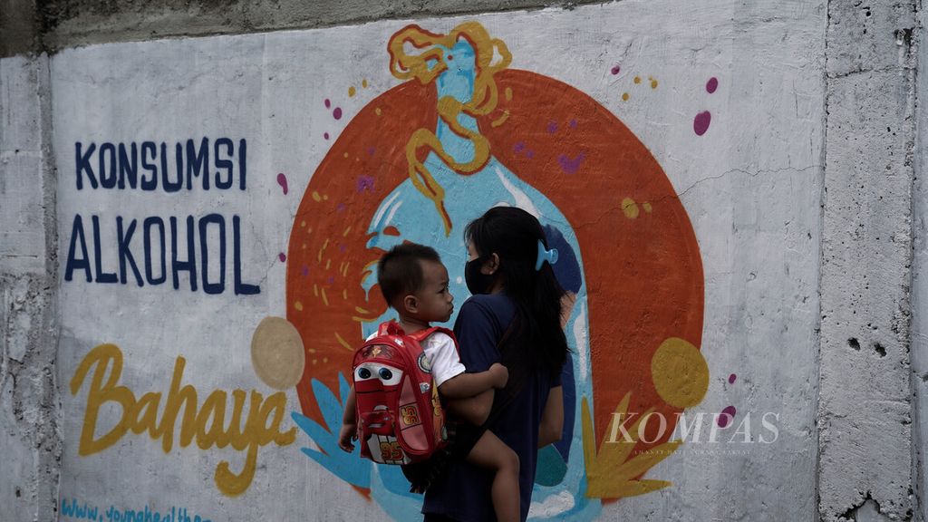 Warga melintasi mural bertema bahaya konsumsi alkohol di Jalan Lontar, Jagakarsa, Jakarta Selatan, Minggu (13/12/2020). 