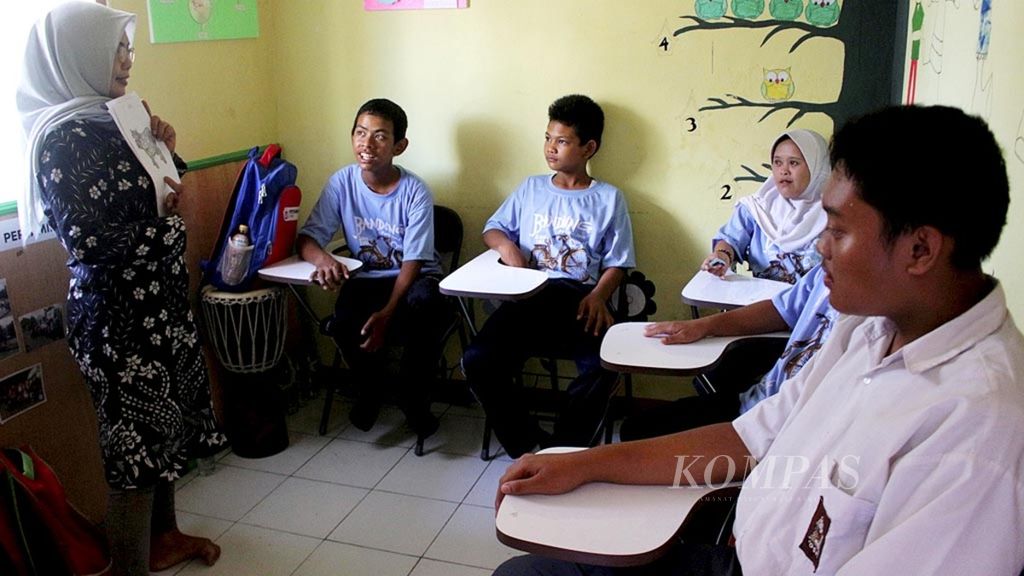 Yulianti (kiri) sedang mengajar siswa berkebutuhan khusus di Sekolah Dreamable Pusat Kegiatan Belajar Masyarakat (PKBM) Hidayah, Dusun Cibisoro, Desa Bojongsari, Kecamatan Bojongsoang, Kabupaten Bandung, Jawa Barat, Senin (15/4/2019).