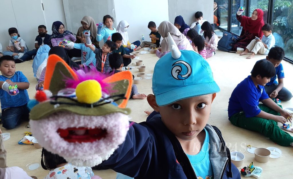 Fathi (7) bermain boneka tangan saat mengikuti perayaan Hari Anak Nasional 2023 di Perpustakaan Jakarta, Sabtu (22/7/2023). Dalam perayaan itu, sekitar 50 anak antusias membaca buku, mendengarkan dongeng, dan membuat boneka tangan atau<i> puppet</i>.