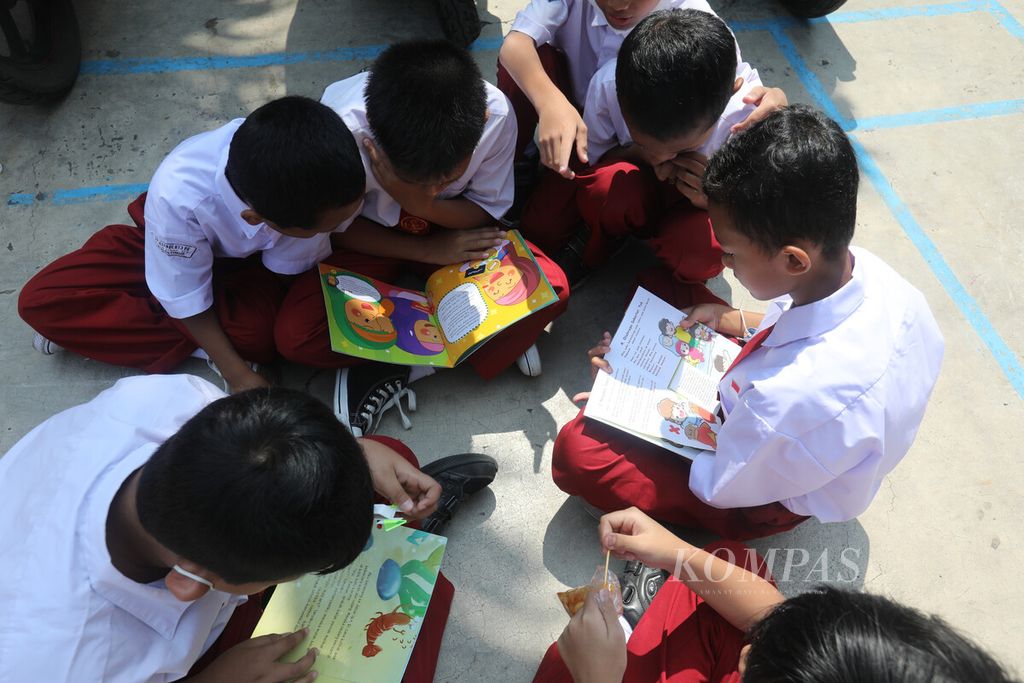 Sejumlah siswa SDN 13 Klender berkumpul saat membaca buku-buku koleksi mobil perpustakaan keliling yang berkunjung ke sekolah mereka di kawasan Klender, Jakarta Timur, Selasa (26/7/2022). Layanan perpustakaan keliling ini menjadi sarana untuk mengenalkan buku dan meningkatkan kebiasaan membaca sejak dini.