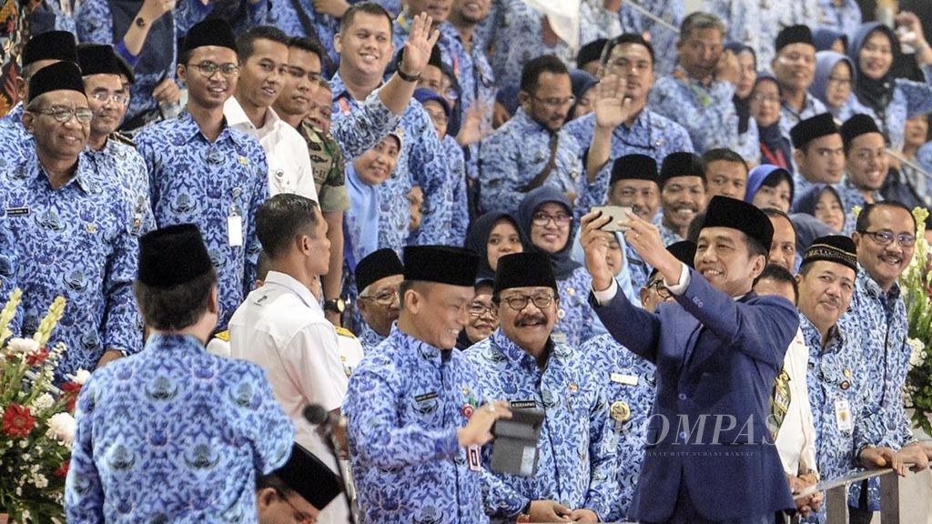 Presiden Joko Widodo mengajak para aparatur sipil negara (ASN) untuk berswafoto saat menghadiri upacara hari ulang tahun ke-47 Korps Pegawai Republik Indonesia (Korpri) di Istora Senayan, Jakarta, Kamis (29/11/2018). 