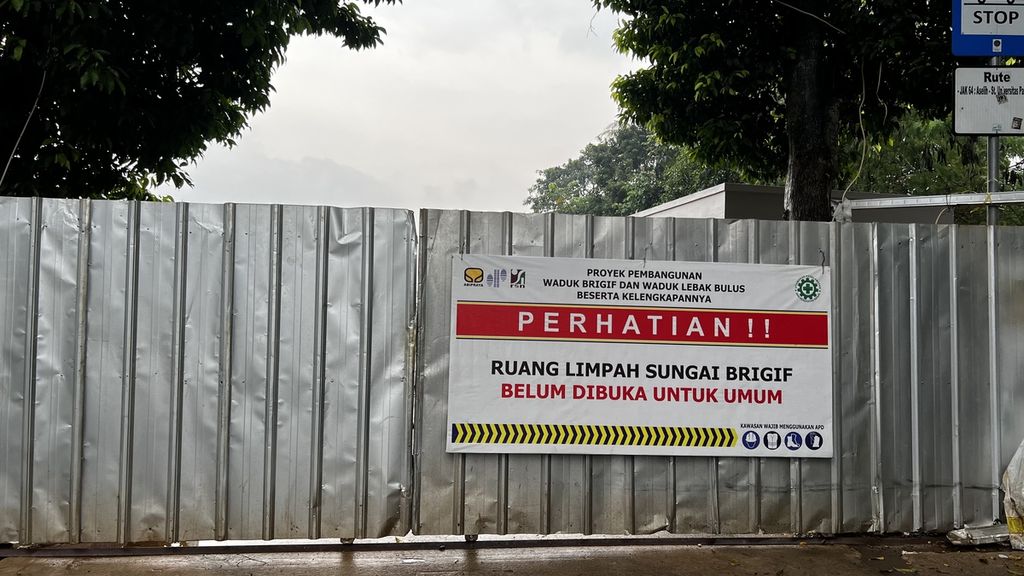 Pemberitahuan larangan masuk untuk umum dipintu masuk Ruang Limpah Sungai Brigif, Jagakarsa, Jakarta Selatan, Senin (5/12/2022)