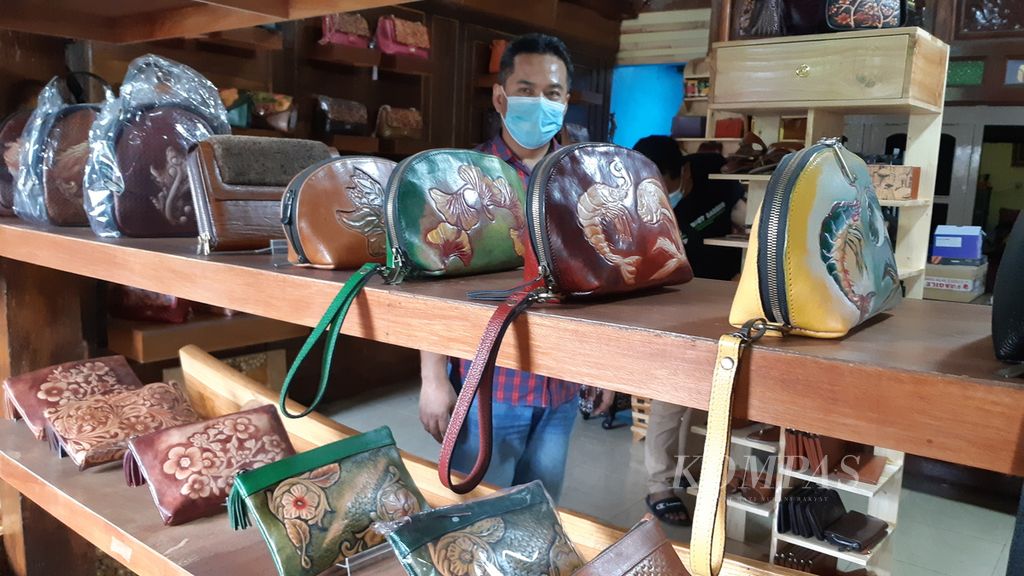 Perajin tas koper kulit Tanggulangin di Sidoarjo, Jawa Timur, Makhbub Junaidi, menunjukkan produknya, Rabu (8/12/2021).