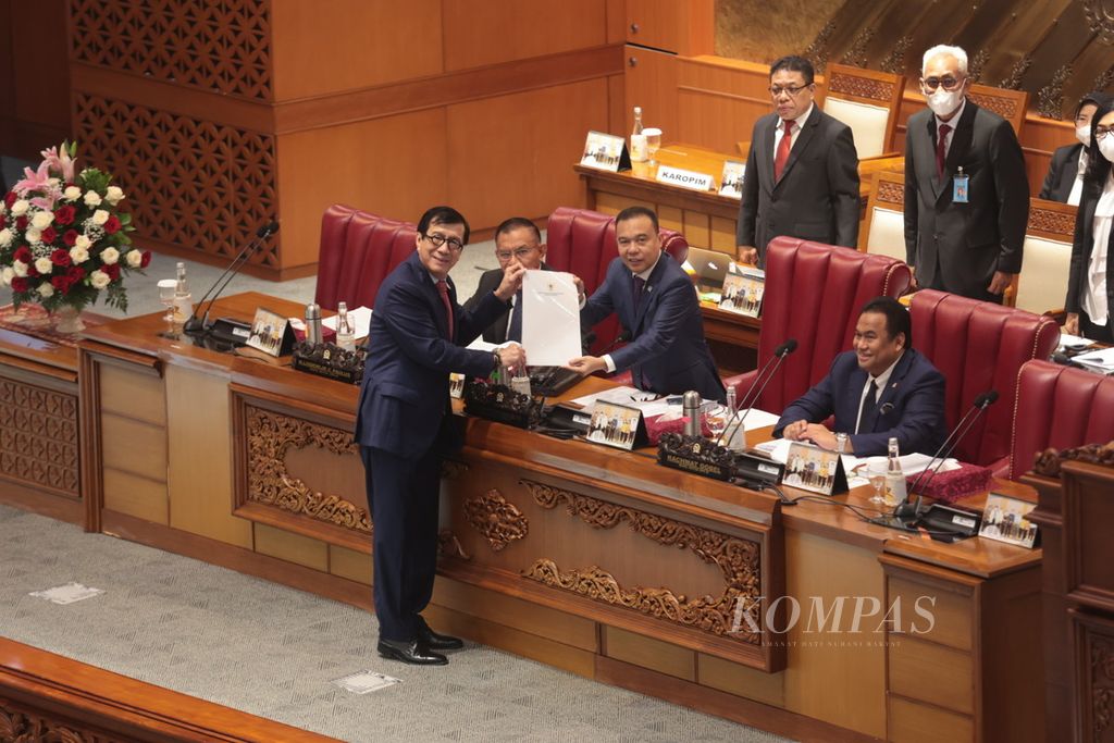  Minister of Law and Human Rights Yasonna H Laoly (left) submits a report on the Draft Criminal Code (RKUHP) to DPR Deputy Speaker Sufmi Dasco Ahmad after giving the government's final views in a plenary meeting at the Parliament Complex, Senayan, Jakarta, Tuesday ( 5/12022). The DPR passed the RKUHP into the Criminal Code..