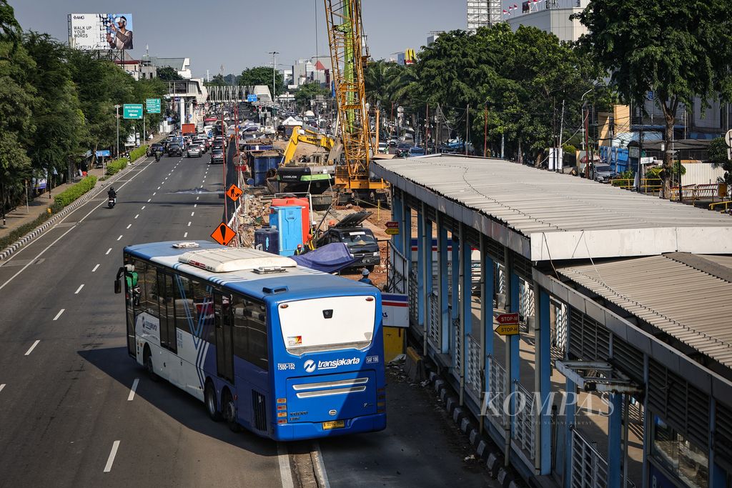 Bus Transjakarta melintasi proyek pembangunan LRT Jakarta fase 1B rute Velodrome-Manggarai di Jalan Pemuda, Rawamangun, Jakarta Timur, Sabtu (16/12/2023).