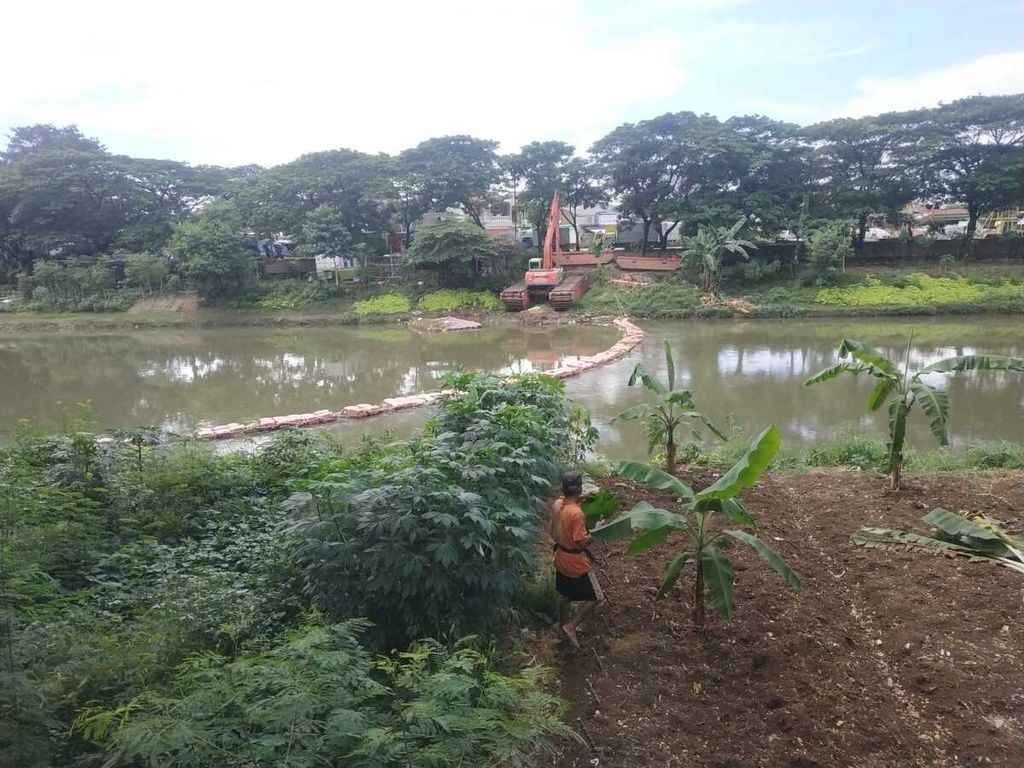 Mohammad Ichsan (59) sedang berada di lahan yang ia manfaatkan sebagai lahan pertanian di bantaran Kanal Banjir Timur di Kelurahan Pulogebang, Kecamatan Cakung, Jakarta Timur, Senin (7/11/2022).