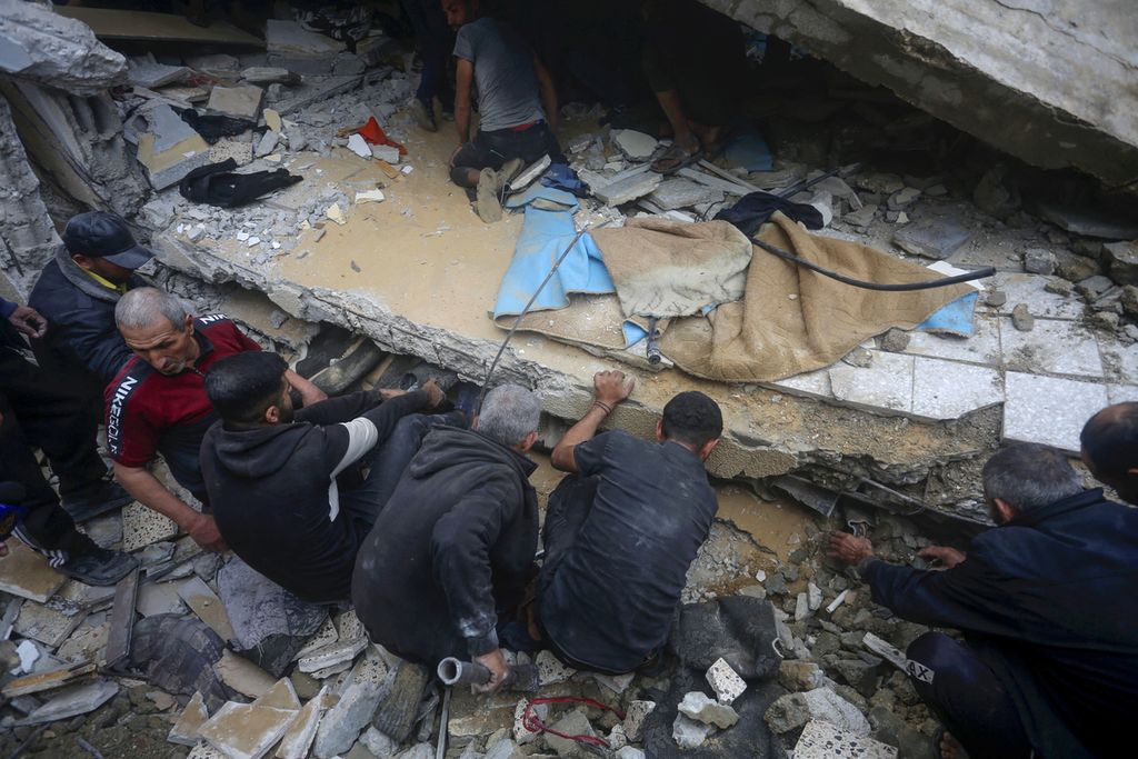 Warga mencari korban di reruntuhan rumah keluarga Baraka di Deir al-Balah di Jalur Gaza tengah setelah tempat itu terkena serangan udara Israel pada 18 Februari 2024.