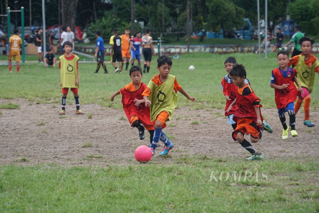 Anak-anak bermain sepak bola di Lapangan Sparta Tikala Manado, Sulawesi Utara, Senin (4/1/2020).