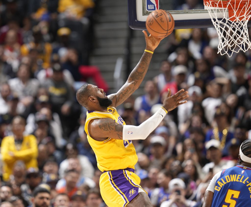 <i>Forward</i> Los Angeles Lakers, LeBron James, mencetak poin saat laga liga bola basket NBA melawan Denver Nuggets di Denver, Rabu (25/10/2023) pagi WIB. Lakers mulai membatasi menit bermain LeBron. 
