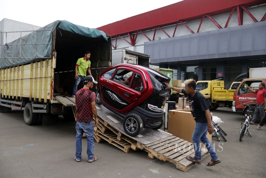 Pekerja menurunkan kendaraan listrik yang akan dipajang di salah satu stan peserta Indonesia International Motor Show 2023 di Jakarta International Expo, Kemayoran, Jakarta, Rabu (15/2/2023). Pameran otomotif ini akan berlangsung pada 16-26 Februari 2023.