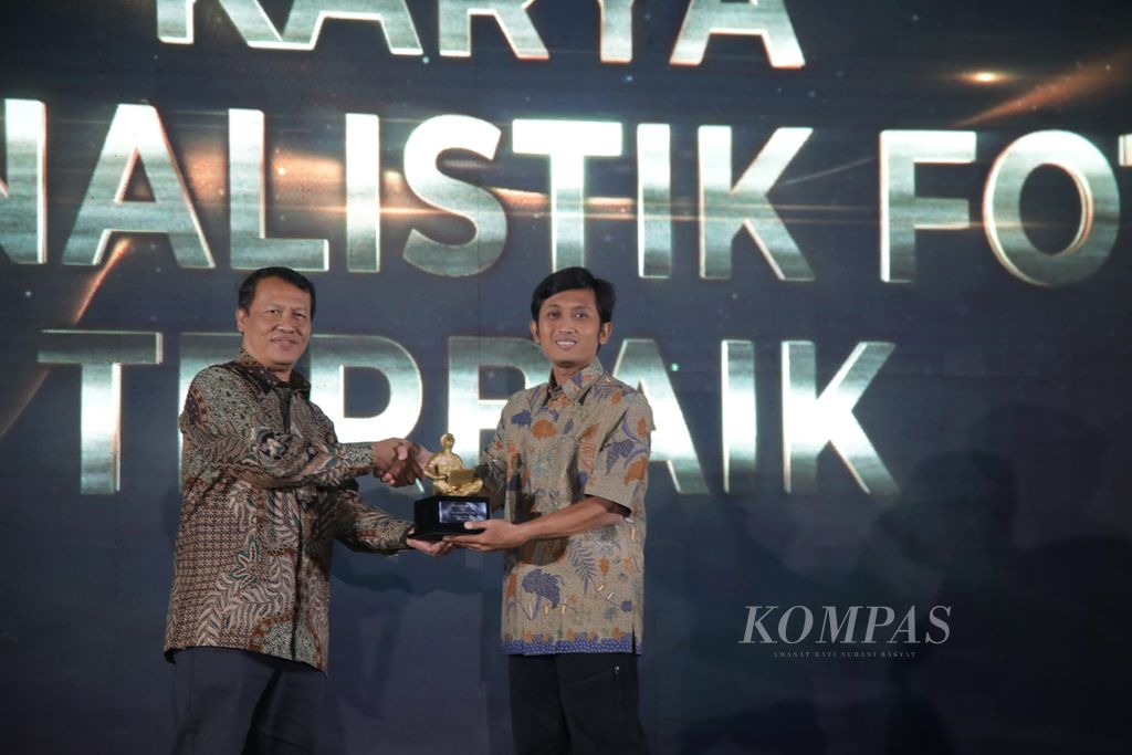 Anggota Dewan Pers, Atmaji Sapto Anggoro (kiri), menyerahkan penghargaan Anugerah Dewan Pers 2022 kepada pewarta foto harian <i>Kompas</i>, Heru Sri Kumoro (kanan), di Kota Bandung, Jawa Barat, Selasa (13/12/2022).