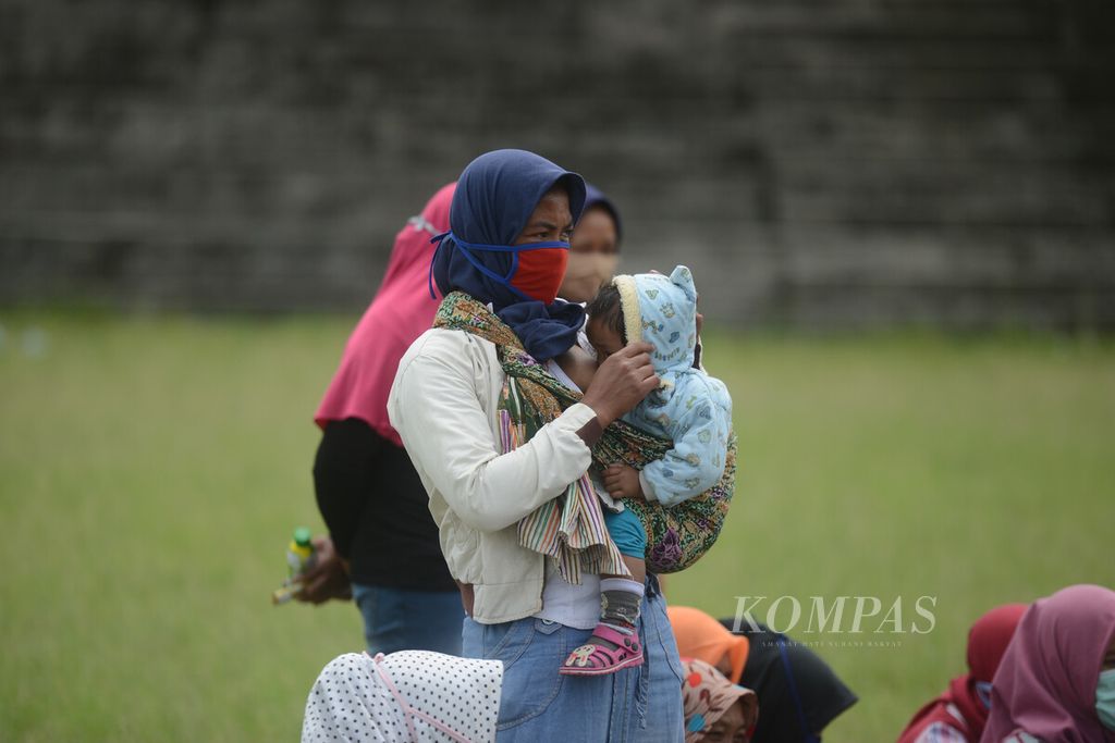 Ibu menyusui membawa anaknya mengikuti kegiatan bermain bersama di lapangan Desa Klakah, Selo, Boyolali, Jawa Tengah, Senin (16/11/2020). 