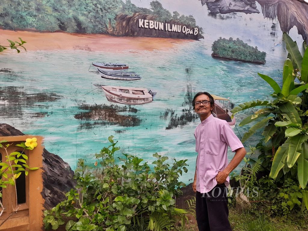 Bagas Sutoko di halaman rumahnya yang berhiaskan mural, di Desa Cempokomulyo, Kepanjen, Kabupaten Malang, Jawa Timur, Rabu (10/5/2023).