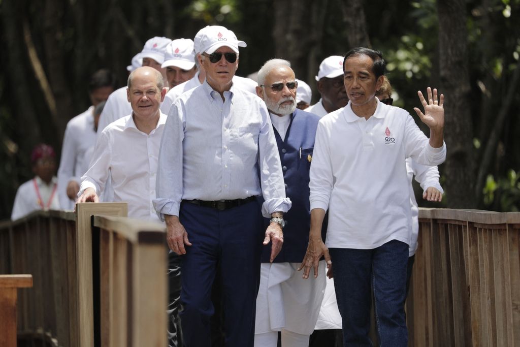 Presiden Indonesia Joko Widodo (kanan) berjalan bersama Presiden AS Joe Biden (kiri depan), Kanselir Jerman Olaf Scholz (kiri belakang), Perdana Menteri India Narendra Modi (belakang tengah) dan para pemimpin lainnya saat acara penanaman pohon di Taman Hutan Raya Ngurah Rai, di sela-sela pertemuan KTT G20 di Nusa Dua, Bali pada 16 November 2022.