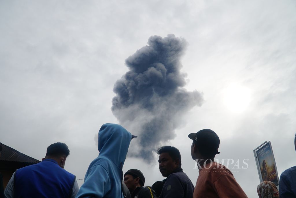 Warga menyaksikan kolom abu yang keluar dari kawah Gunung Marapi di posko utama SAR di Kantor Wali Nagari Batupalano, Kecamatan Sungai Pua, Agam, Sumatera Barat, Senin (4/12/2023). 