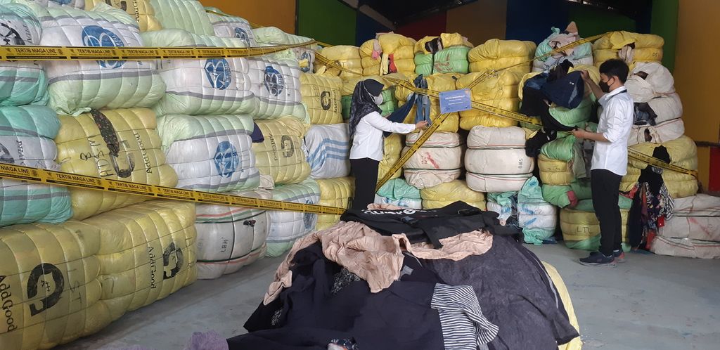 Pegawai Kemendag memeriksa 824 bal baju bekas impor senilai Rp 10 miliar di kompleks pergudangan Jaya Park Sidoarjo, Jatim, Senin (20/3/2023). Baju ilegal itu dimusnahkan dengan cara dibakar agar tidak diperdagangkan