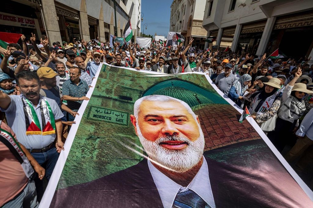 Demonstran mengangkat plakat dan bendera Palestina selama unjuk rasa di Rabat, Maroko, 3 Agustus 2024, untuk memprotes pembunuhan pemimpin kelompok militan Palestina Hamas, Ismail Haniyeh.