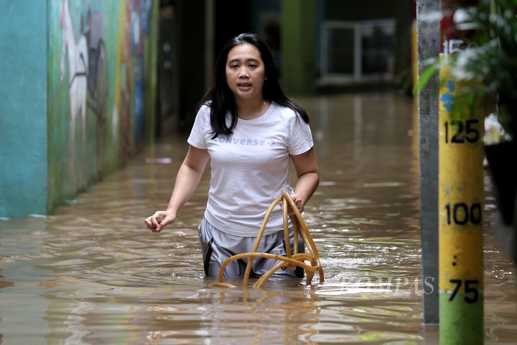 Warga melintasi banjir di Kelurahan Kampung Melayu, Kecamatan Jatinegara, Jakarta Timur, Jumat (15/3/2024).