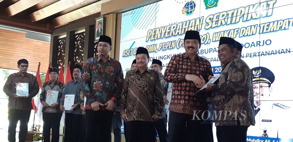 Menteri Agraria Tata Ruang/Kepala BPN Marsekal TNI (Purn) Hadi Tjahjono saat menyerahkan sertifikat tanah di Sidoarjo, Jawa Timur, Jumat (5/5/2023). 