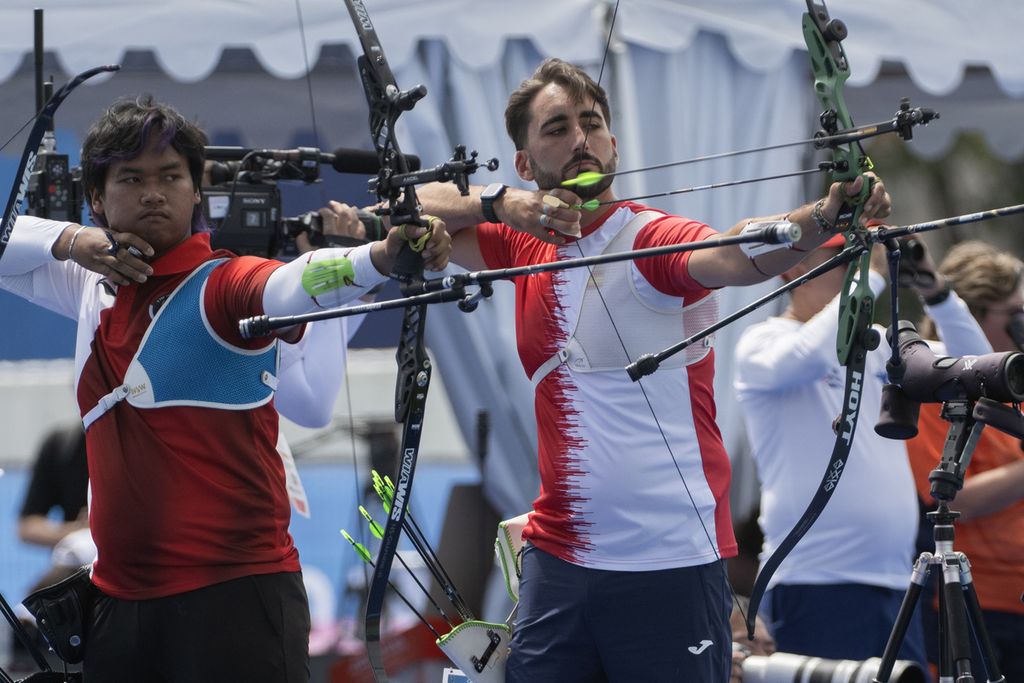 Pemanah putra Indonesia, Arif Dwi Pangestu (kiri), melepaskan anak panah ke sasaran saat mengikuti babak kualifikasi panahan nomor perorangan putra Olimpiade Paris 2024 di Esplanade des Invalides, Paris, Perancis, Kamis (25/7/2024). Arif Dwi Pangestu berada di urutan ke-40 dengan mengumpulkan poin sebanyak 656. 