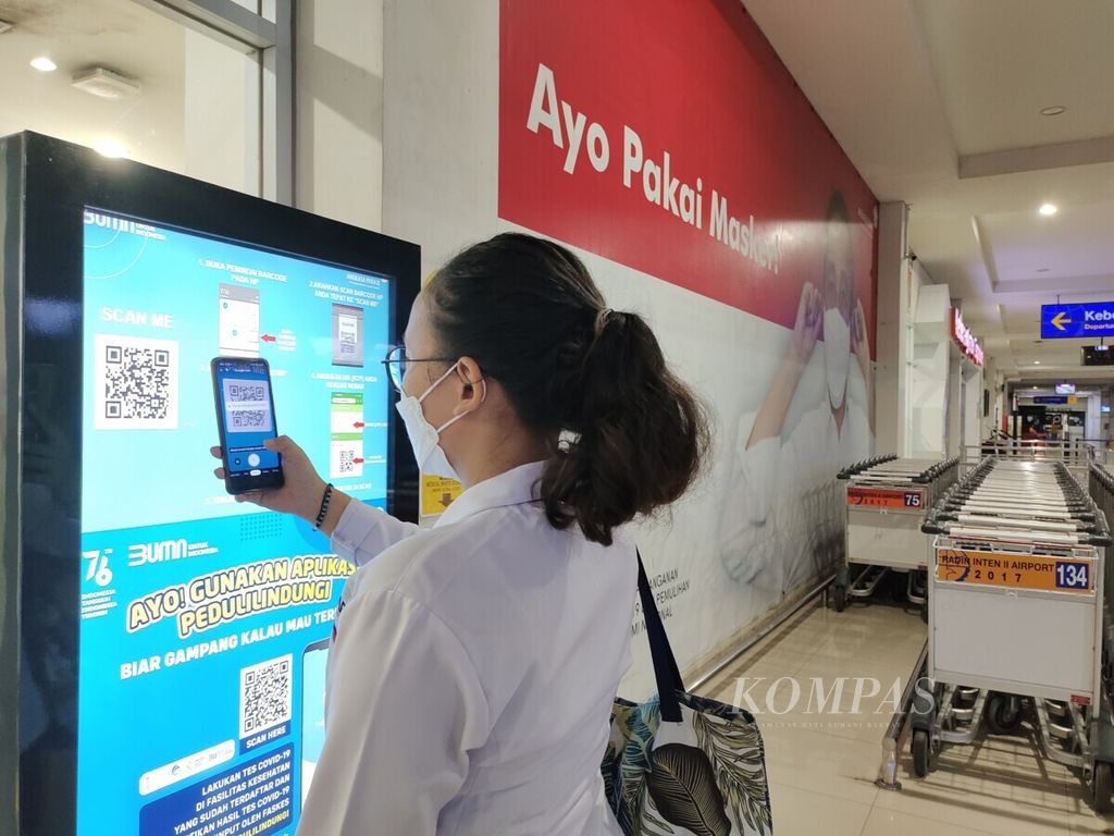 Calon penumpang sedang mengkases aplikasi Peduli Lindungi melalui gawai di Bandara Radin Inten II Lampung, Kamis (16/12/2021). 