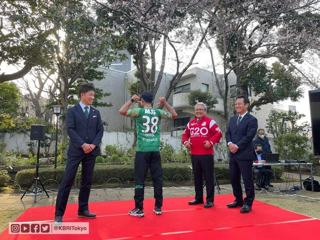 Pratama Arhan (kedua dari kiri) menunjukkan nomor punggung yang dikenakannya di Tokyo Verdy, tim Liga 2 Jepang, untuk musim 2022 pada perkenalan perekrutan Arhan oleh Tokyo Verdy, tim Liga 2 Jepang, Jumat (25/3/2022), di Kedutaan Besar RI Tokyo, Jepang. Pada acara itu, Arhan didampingi Duta Besar Indonesia untuk Jepang Heri Akhmadi (jaket merah) serta perwakilan Tokyo Verdy, Manajer Umum Atsuhiko Ejiri (kiri) dan CEO Takaaki Nakamura (kanan).