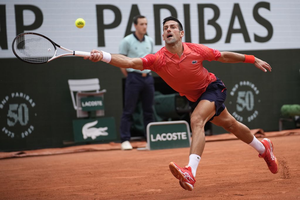 Novak Djokovic menjangkau bola saat melawan Casper Ruud laga final Grand Slam Perancis Terbuka di Roland Garros, Paris, Minggu (11/6/2023).