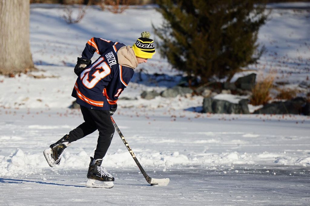 Dalam foto yang diambil pada Minggu (21/1/2024) tampak seorang remaja pemain hockey tengah berlatih di sebuah arena di sebuah taman yang membeku di Old Westbury, New York. 