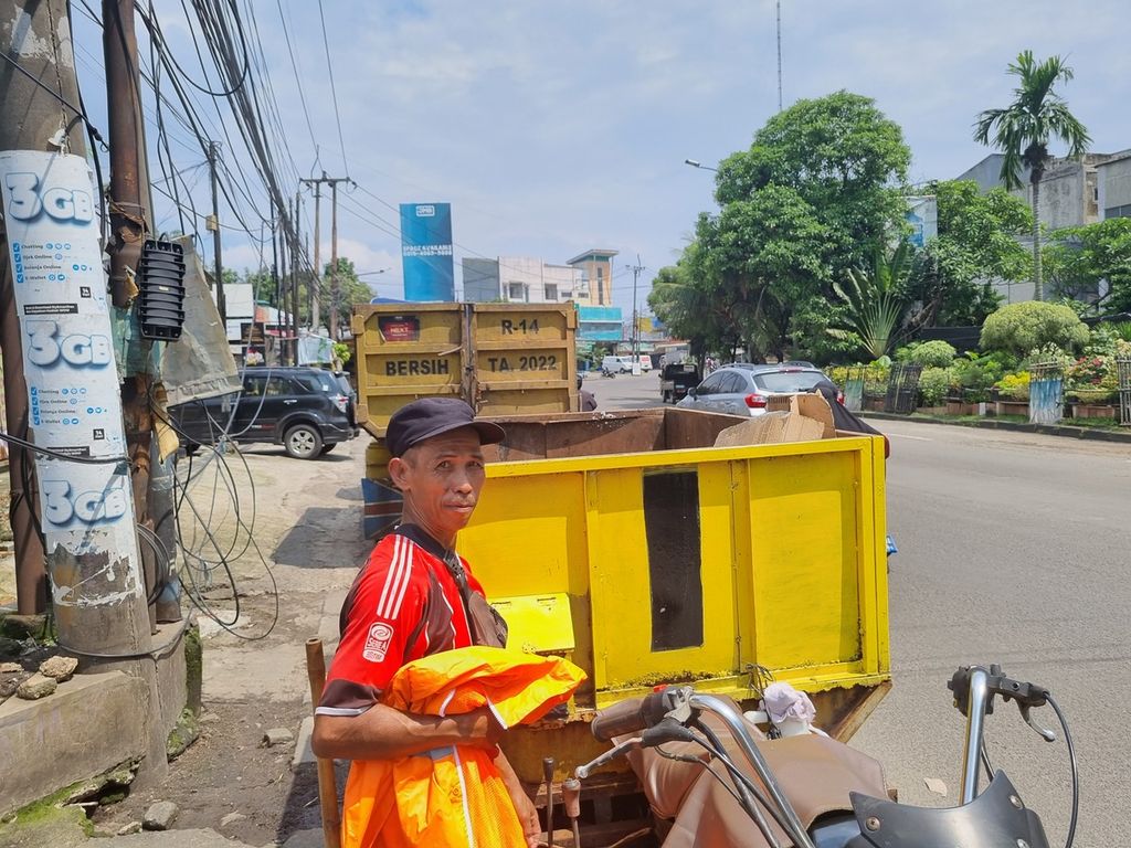 Seorang petugas kebersihan Dinas Lingkungan Hidup dan Kebersihan Kota Tangerang usai membersihkan dan mengangkut sampah di Jalan Hos Cokroaminoto, Kamis (5/1/2023).