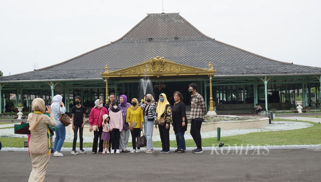 Para wisatawan berfoto di kompleks Pura Mangkunegaran, Kota Surakarta, Jawa Tengah, Kamis (29/12/2022). Sejumlah kegiatan budaya ditambahkan untuk menambahkan atraksi di kadipaten tersebut. 