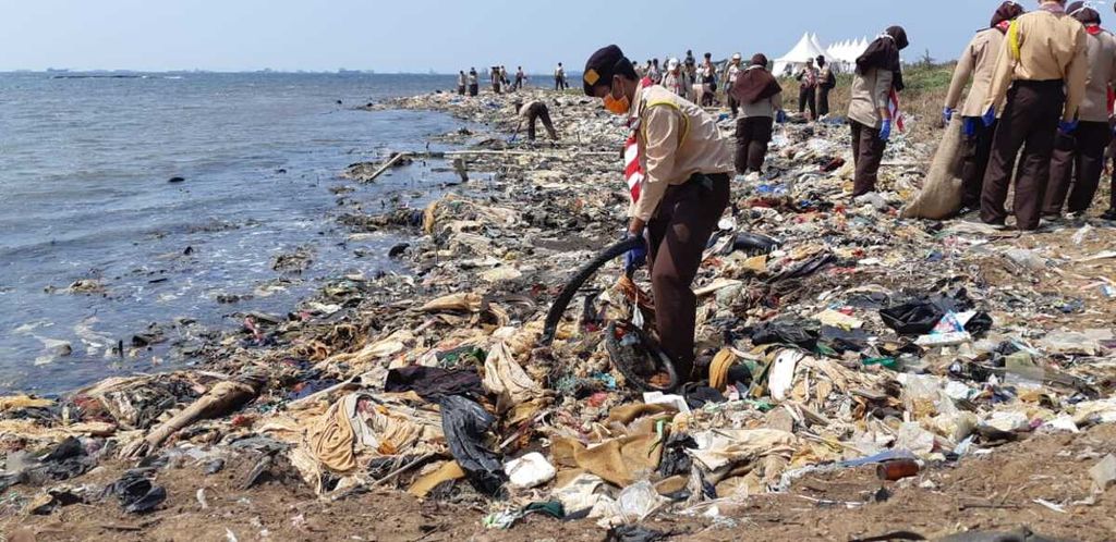 Salah satu peserta gerakan Menghadap Laut sedang membersihkan sampah di Pantai Ancol Timur, Jakarta Utara, Minggu (19/8/2018). 