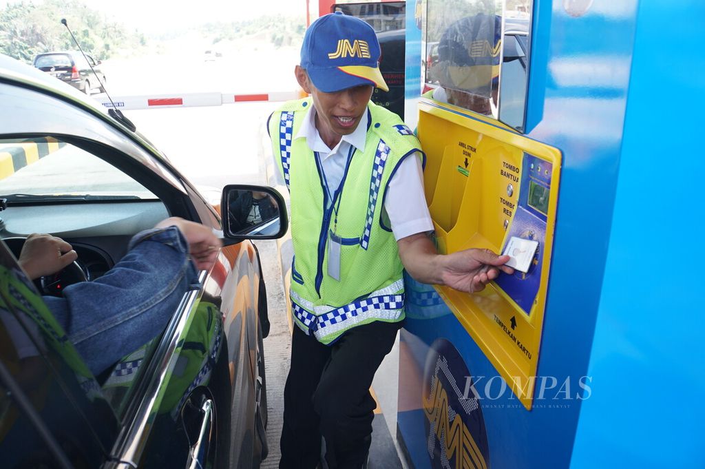 Petugas PT Jasamarga Manado Bitung membantu pengendara menempelkan kartu uang elektronik pada mesin pembayaran di Gerbang Tol Manado, Jalan Tol Manado-Bitung, Manado, Sulawesi Utara, Sabtu (28/12/2019).