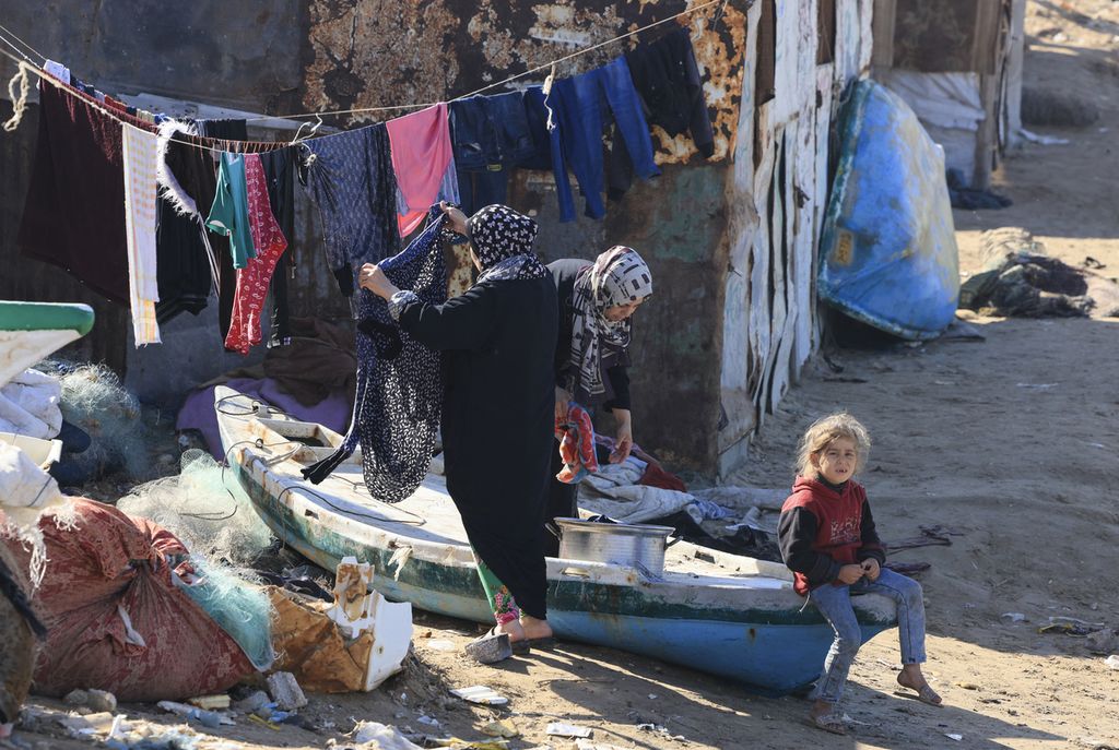 Warga Palestina yang mengungsi menggantung cucian mereka di pantai di Deir el-Balah di Jalur Gaza, Kamis (30/11/2023). 