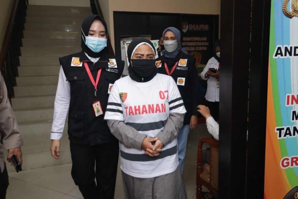 Polisi menggiring tersangka penempatan buruh migran secara ilegal, Dina Syiwandari (40), di Markas Polda Kepulauan Riau, Rabu (17/3/2021).