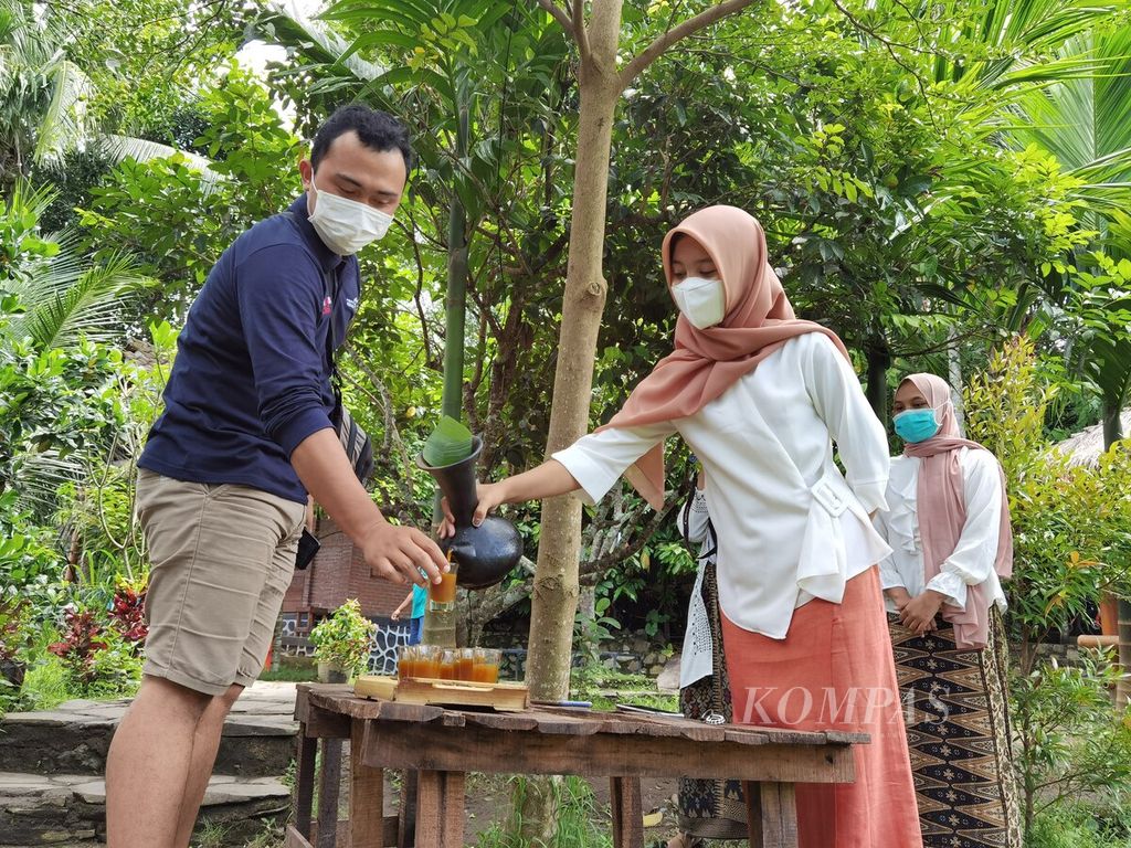 Anggota Kelompok Sadar Wisata Bonjeruk Permai Desa Bonjeruk, Kecamatan Jonggat, Kabupaten Lombok Tengah, Nusa Tenggara Barat, menuangkan minuman selamat datang untuk menyambut tamu yang datang berkunjung ke desa wisata itu, Kamis (25/2/2021). Di tengah pandemi, Desa Wisata Bonjeruk, yang merupakan salah satu desa penyangga Kawasan Ekonomi Khusus (KEK) Mandalika, tetap berkegiatan, terutama untuk paket <i>food and beverage</i>.