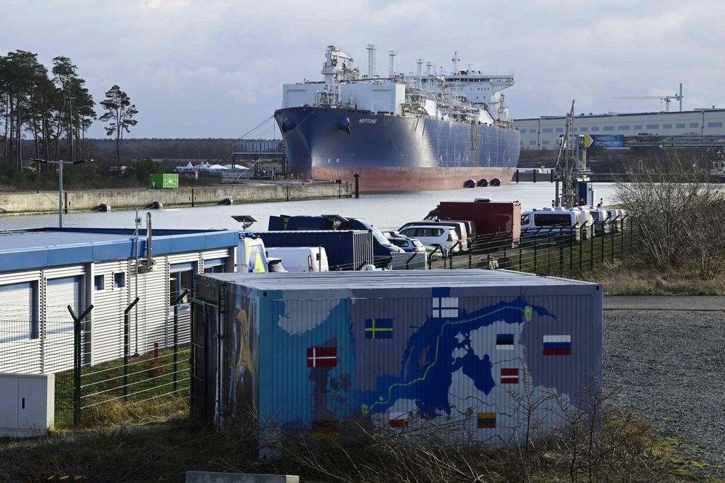 Unit penyimpanan terapung dan regasifikasi Neptune tampak di belakang kontainer bergambar peta jaringan pipa gas bawah laut Nord Stream 2 di kawasan industri Lubmin, Jerman, 14 Januari 2023.