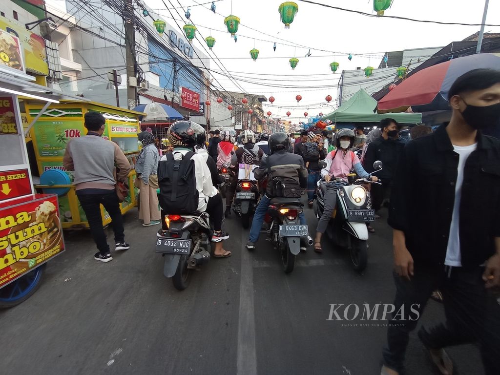 Suasana di pusat kuliner Pasar Lama di Kota Tangerang, Banten, Kamis (14/4/2022). Pengunjung dan pengendara berbagi ruang di antara lapak pedagang kaki lima di kiri dan kanan jalan.