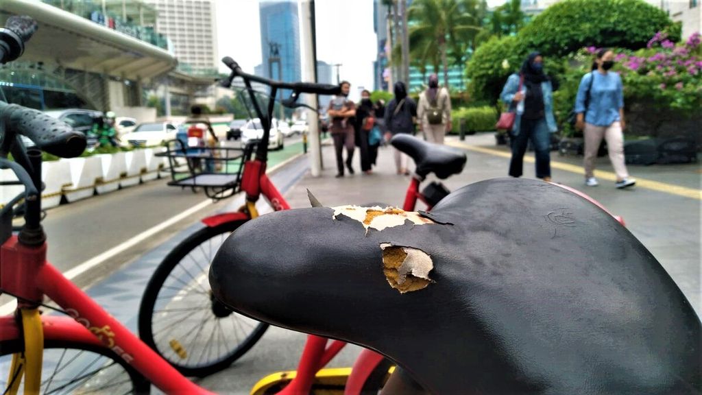 Masyarakat berlalu lalang di sekitar layanan Bike Sharing sekitar Stasiun MRT Bundaran HI, Jakarta Pusat, Sabtu (15/10/2022). Jok sepeda telah sobek dan berlubang.