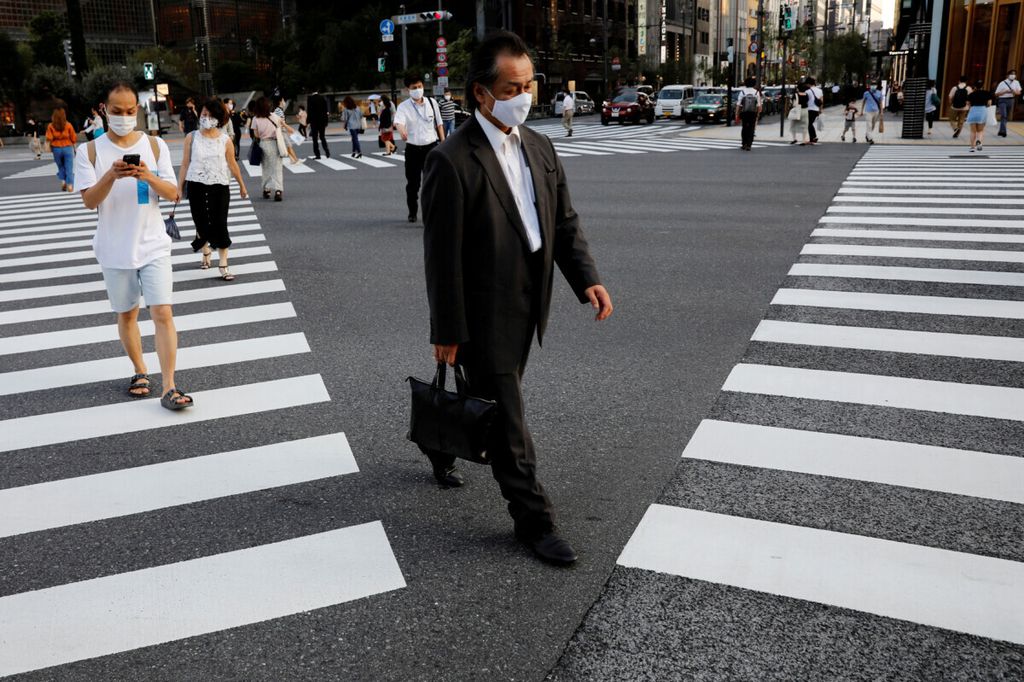 People wearing protective masks make their way amid the coronavirus disease (COVID-19) pandemic at a business district in Tokyo, Japan August 4, 2020. 