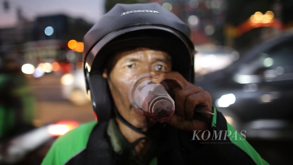 Pengendara sepeda motor yang melintas di Jalan Penjernihan, Jakarta Pusat, berbuka puasa dengan makanan dan minuman yang dibagikan di Pos Pemadam Kebakaran Bendungan Hilir, Rabu (8/5/2019). Banyak warga yang berbuka puasa dalam perjalanan pulang dari pekerjaan saat menembus kepadatan lalu lintas di Ibu Kota.