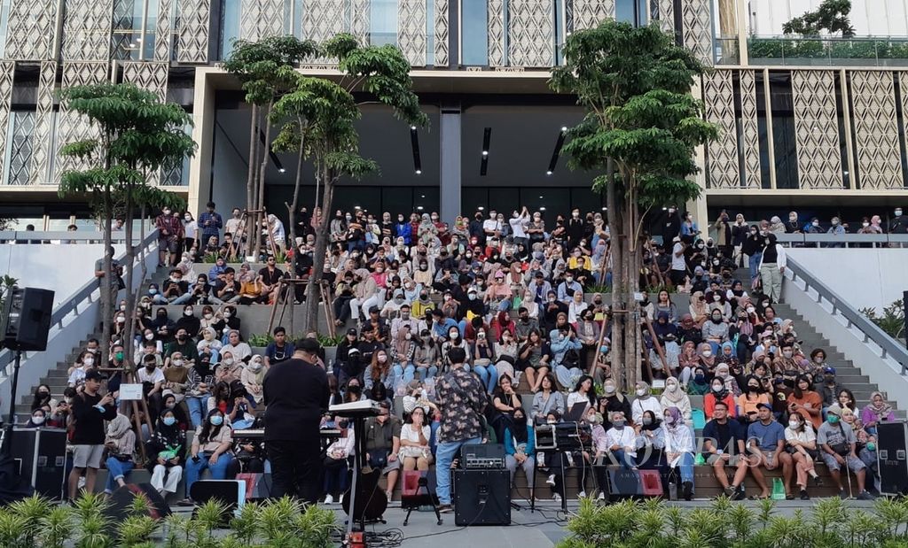 Pengunjung menyaksikan pertunjukan musik di halaman Gedung Sarinah, DKI Jakarta, Sabtu (11/6/2022). Penerapan protokol kesehatan Covid-19 di sejumlah lokasi mulai longgar. 