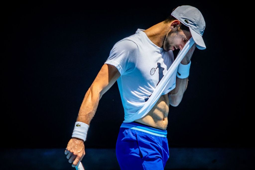 Novak Djokovic menyeka wajahnya pada sesi latihan di Melbourne, Australia, Kamis (12/1/2023), dalam persiapan mengikuti Grand Slam Australia Terbuka 2023, 16-29 Januari 2023. 