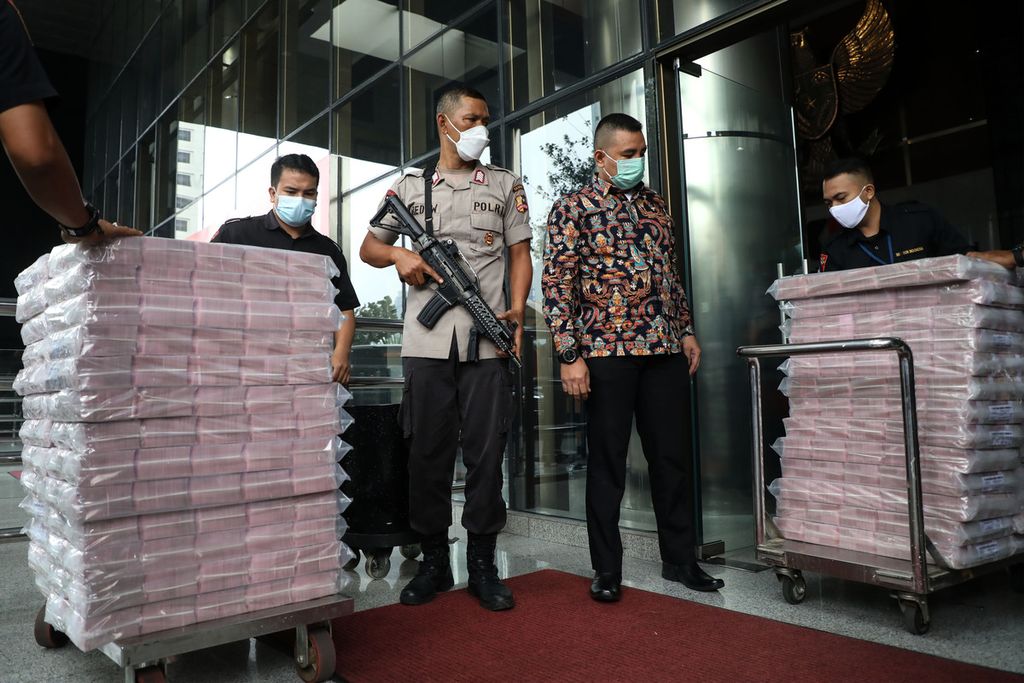 Petugas kepolisian mengawal ketat pemindahan uang Rp 52,3 miliar hasil sitaan dari sebuah bank dalam kasus dugaan suap terkait izin ekspor benih lobster atau benur di Kementerian Kelautan dan Perikanan dari gedung Gedung Komisi Pemberantasan Korupsi (KPK) Jakarta menuju gudang penyimpanan, Senin (15/3/2021).