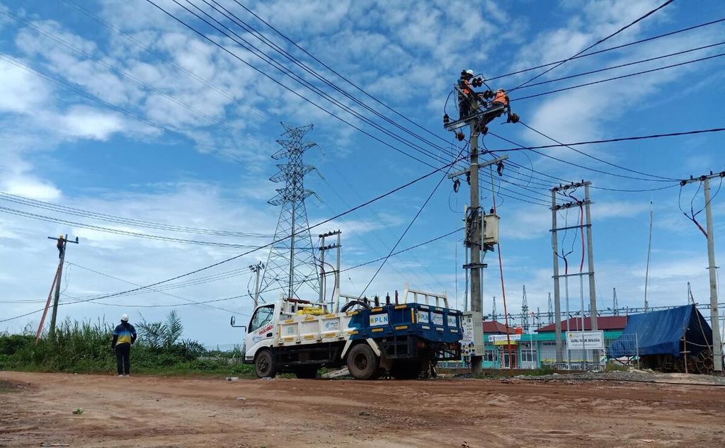 Petugas  PT Perusahaan Listrik Negara (PLN) Unit Induk Distribusi Lampung memasang jaringan listrik di kawasan Bumi Dipasena, Kecamatan Rawajitu Timur, Kabupaten Tulang Bawang, Lampung, pada Agustus 2020. 