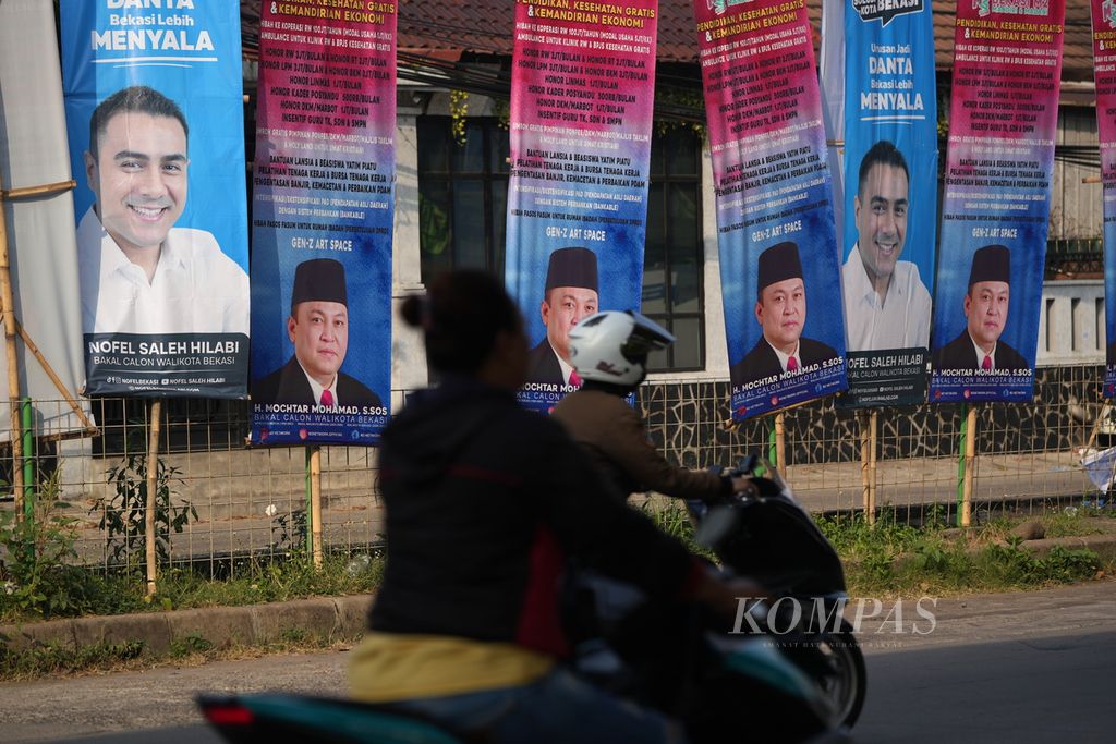 Warga melintasi baliho bakal calon wali kota yang akan maju dalam Pilkada Kota Bekasi 2024 di Pondok Gede, Kota Bekasi, Jawa Barat, Selasa (23/7/2024). 