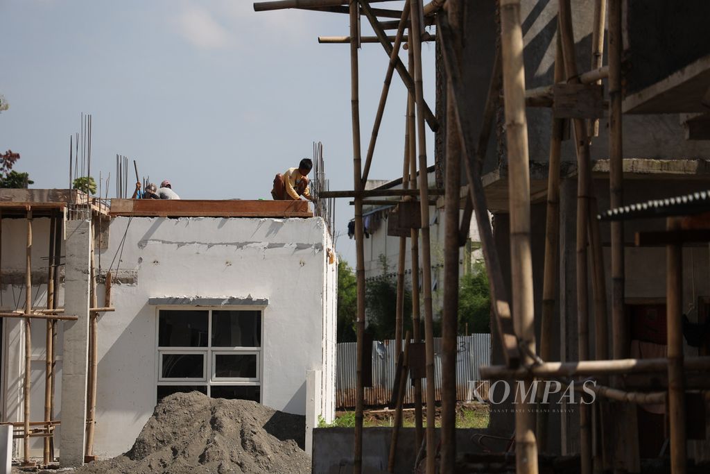 Pekerja menyelesaikan pembangunan rumah di sebuah kompleks perumahan yang berada di tanah desa di Desa Caturtunggal, Kecamatan Depok, Kabupaten Sleman, Daerah Istimewa Yogyakarta, Minggu (3/7/2022). 