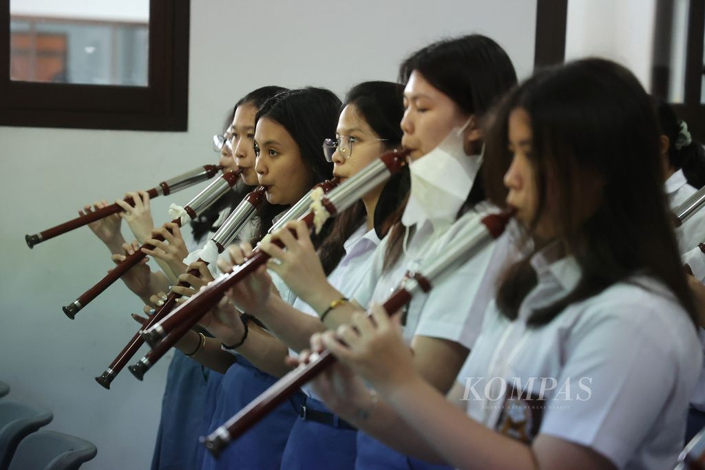 Murid SMA belajar memainkan lagu berjudul ”Wo He Ni” dengan alat musik bawu dari Yunan dalam acara Chinese Culture Camp di Sekolah Budi Utama, Kecamatan Mlati, Sleman, DI Yogyakarta, Senin (17/7/2023).